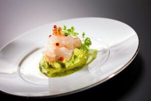 Un plato blanco con un plato de mariscos sobre un fondo oscuro.