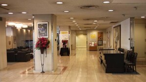 A hotel lobby with a reception desk, seating area, and a reception counter.