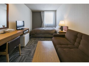 A hotel room with a bed, a desk with a television, a sofa, and a lamp. - Sunroute Tokuyama (Shunan)