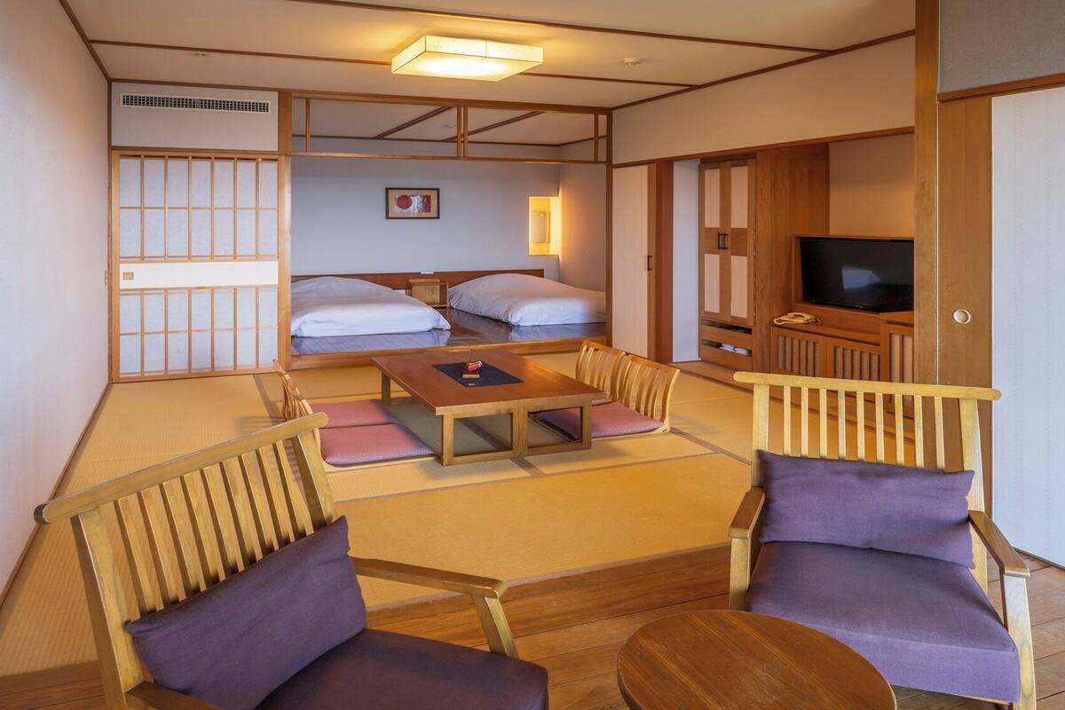 Een traditionele Japanse kamer met tatami vloerbedekking, een lage tafel en houten meubilair.