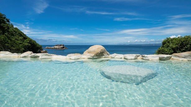 A clear pool with rocks and a view of the ocean. - Hamadachidori no Yu Kaishu (Shirahama)