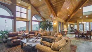 A spacious living room with leather sofas, a coffee table, and a dining area with a large table and chairs.