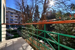 Enjoy the view from this balcony overlooking the parking area and surrounding buildings.
