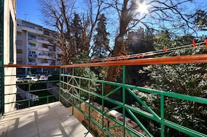 Enjoy the view from this balcony overlooking the parking area and surrounding buildings.