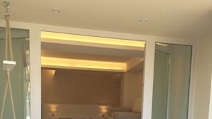 A compact room with a dining area, a bed, and a small seating area.