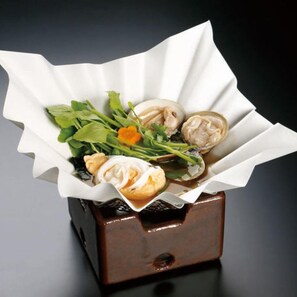 A dish with clams and greens in a paper-lined container. - Iki Sakana Senmon Ryokan Atarashiya (Wakayama)