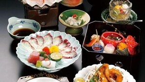 A variety of dishes arranged on a table, including sashimi, sushi, and other Japanese cuisine. - Iki Sakana Senmon Ryokan Atarashiya (Wakayama)