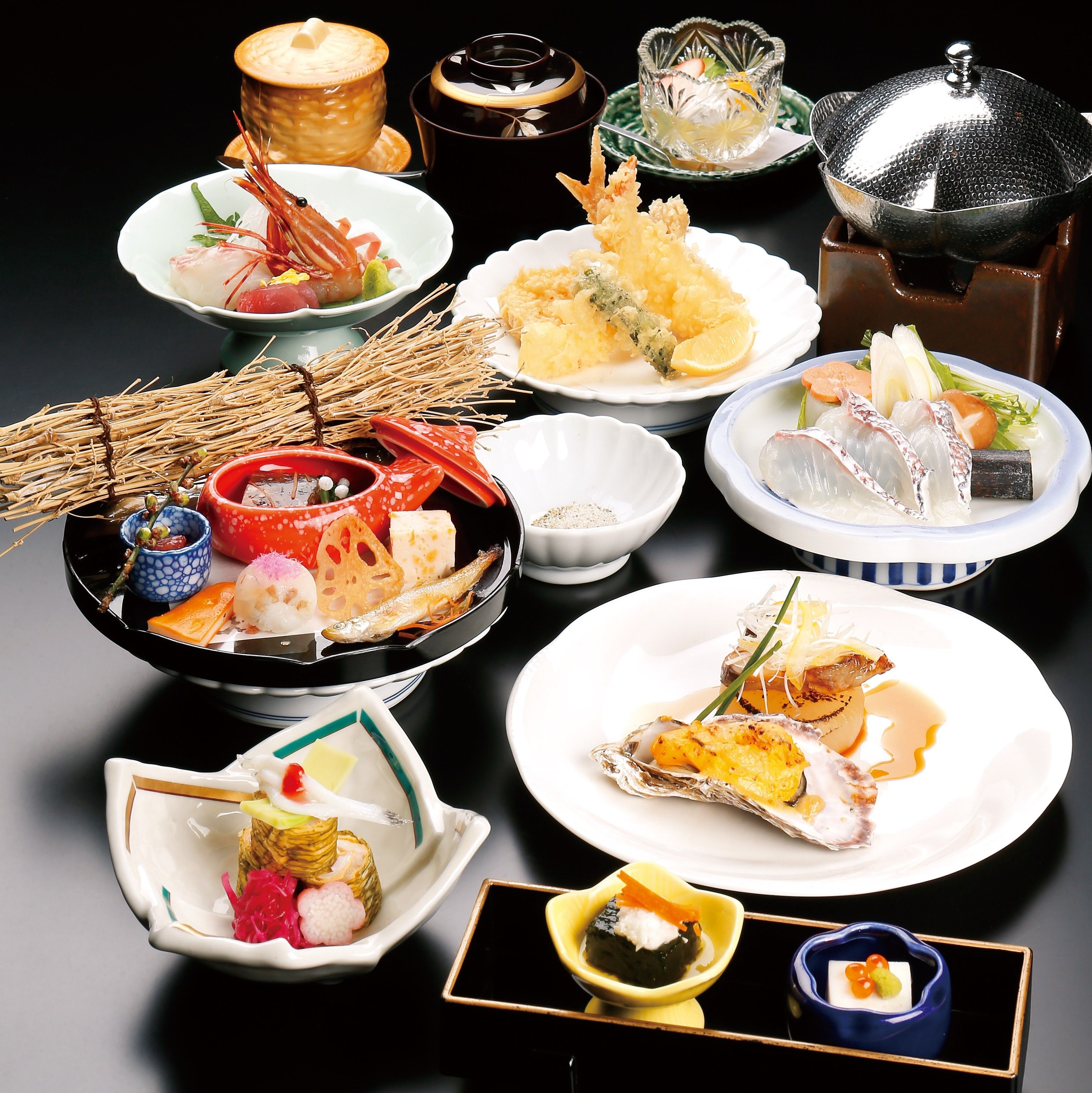 A variety of Japanese dishes arranged on a table, including sushi, sashimi, and tempura.