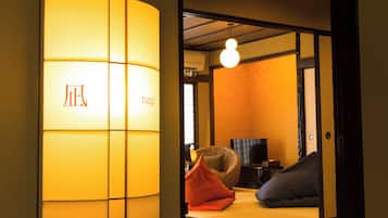 Un interior japonés tradicional con puertas correderas, una lámpara, un sofá y un televisor.