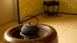 Een traditionele theepot op een houten voetstuk.