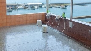 A room with a large window, a wet floor, and a view of boats and water. - Iki Sakana Senmon Ryokan Atarashiya (Wakayama)
