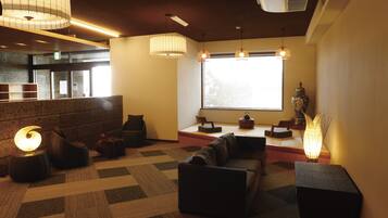 A modern interior with seating areas, a large window, and a decorative vase.