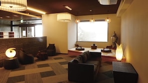 A modern interior with seating areas, a large window, and a decorative vase. - Iki Sakana Senmon Ryokan Atarashiya (Wakayama)