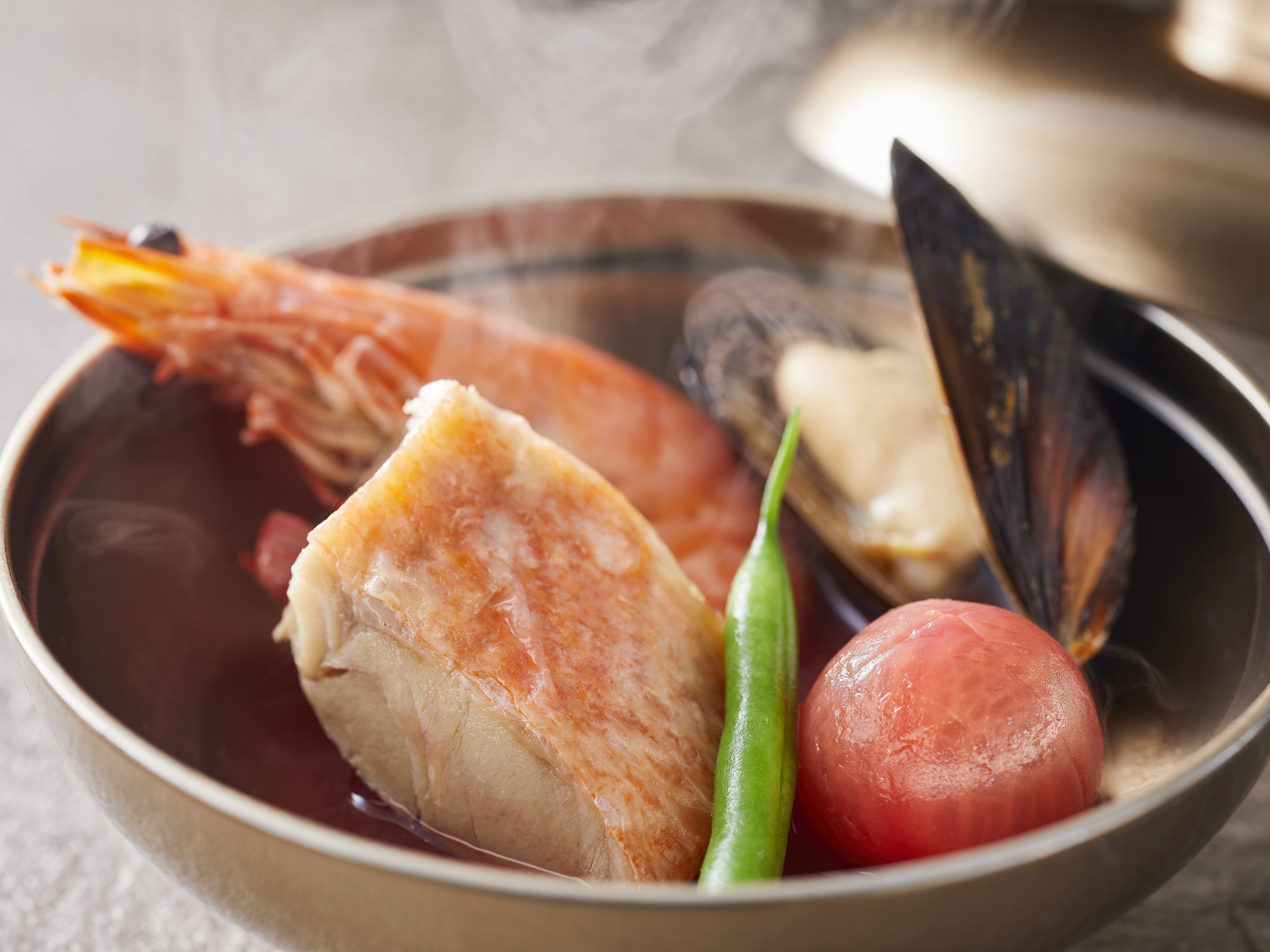 A bowl of seafood soup with shrimp, mussels, and other ingredients.