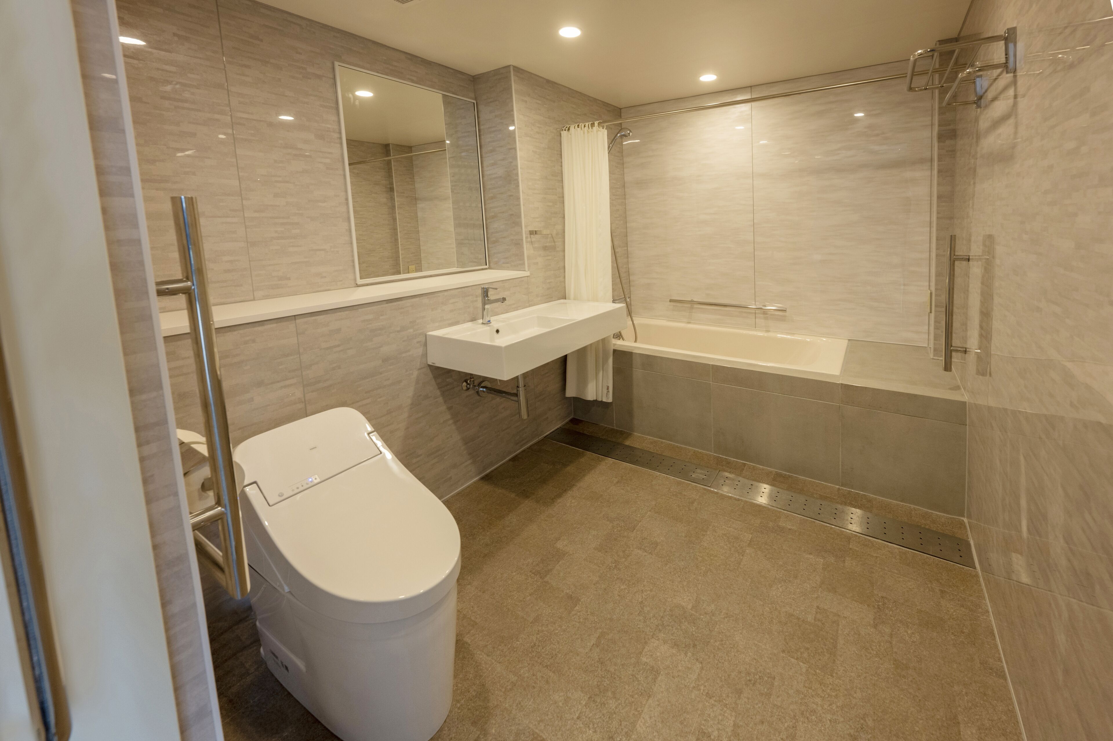 Un baño moderno con inodoro, lavamanos y bañera.