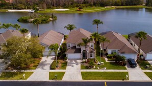 A residential area with houses, a golf course, and a lake. - Luxury 6BR / 3.5 Bathroom villa near Disney. Pool, Hot Tub, Games Room, etc. (Kissimmee)
