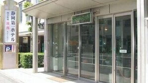 A modern building with a glass entrance and a sign indicating a hotel. - Shizuoka Daiichi Hotel (Shizuoka)