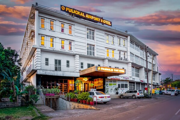 Un hotel con un cartel que dice "Pulical Airport Hotel" y una entrada visible.
