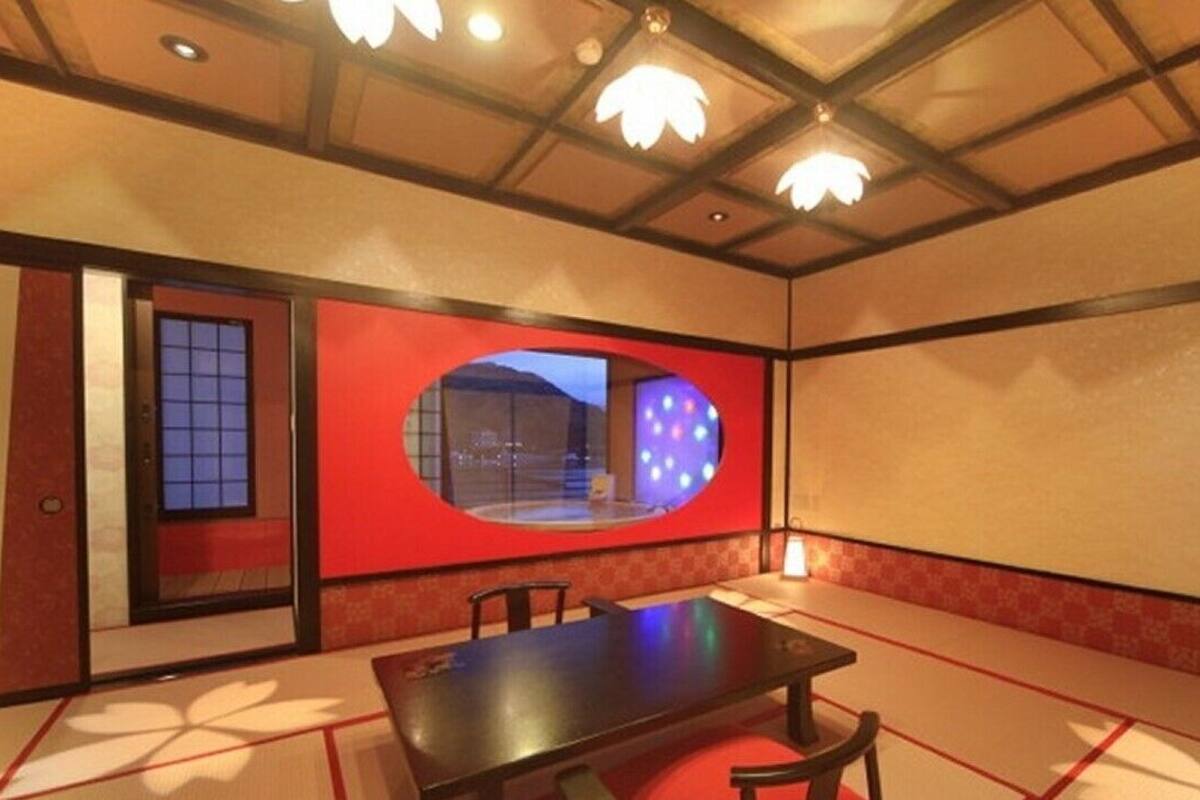 A traditional Japanese room with tatami flooring, a low table, and a sliding door.