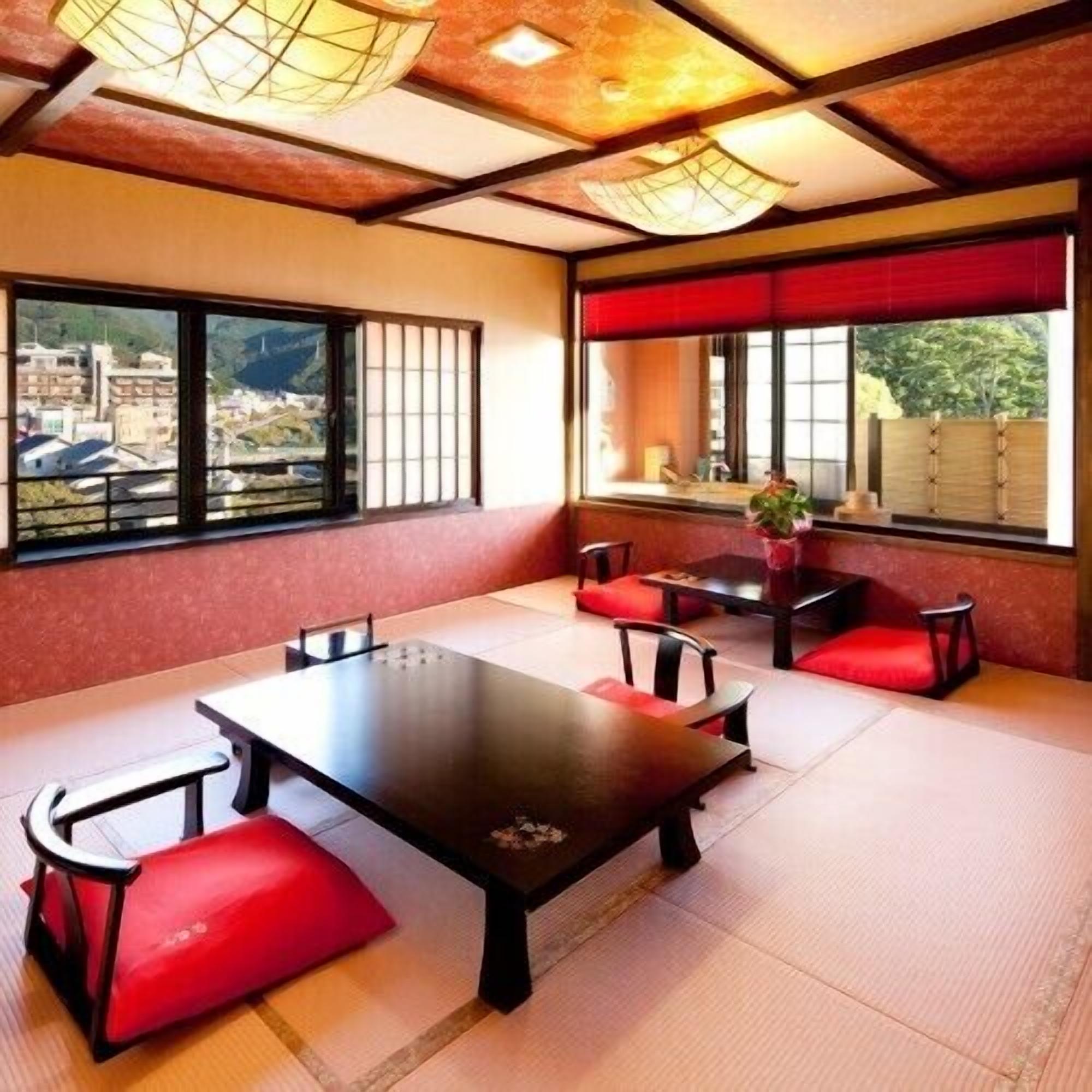 A traditional Japanese-style room with tatami flooring, a low table, and red cushions.