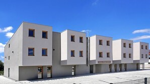 Un hotel moderno con fachada plana, varias ventanas y un letrero que indica que es un hotel 'easy sleep'.