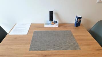 Una mesa de madera con un control remoto, una caja con la etiqueta 'sky' y un router WiFi.