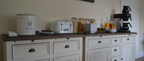 A kitchen counter with a coffee maker, toaster, and jars of condiments.