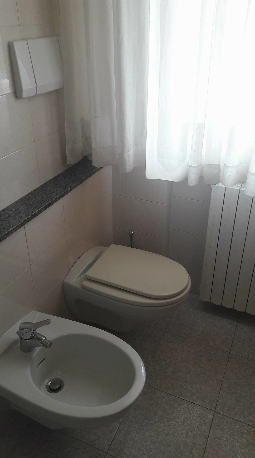 A bathroom with a toilet, bidet, and sink.