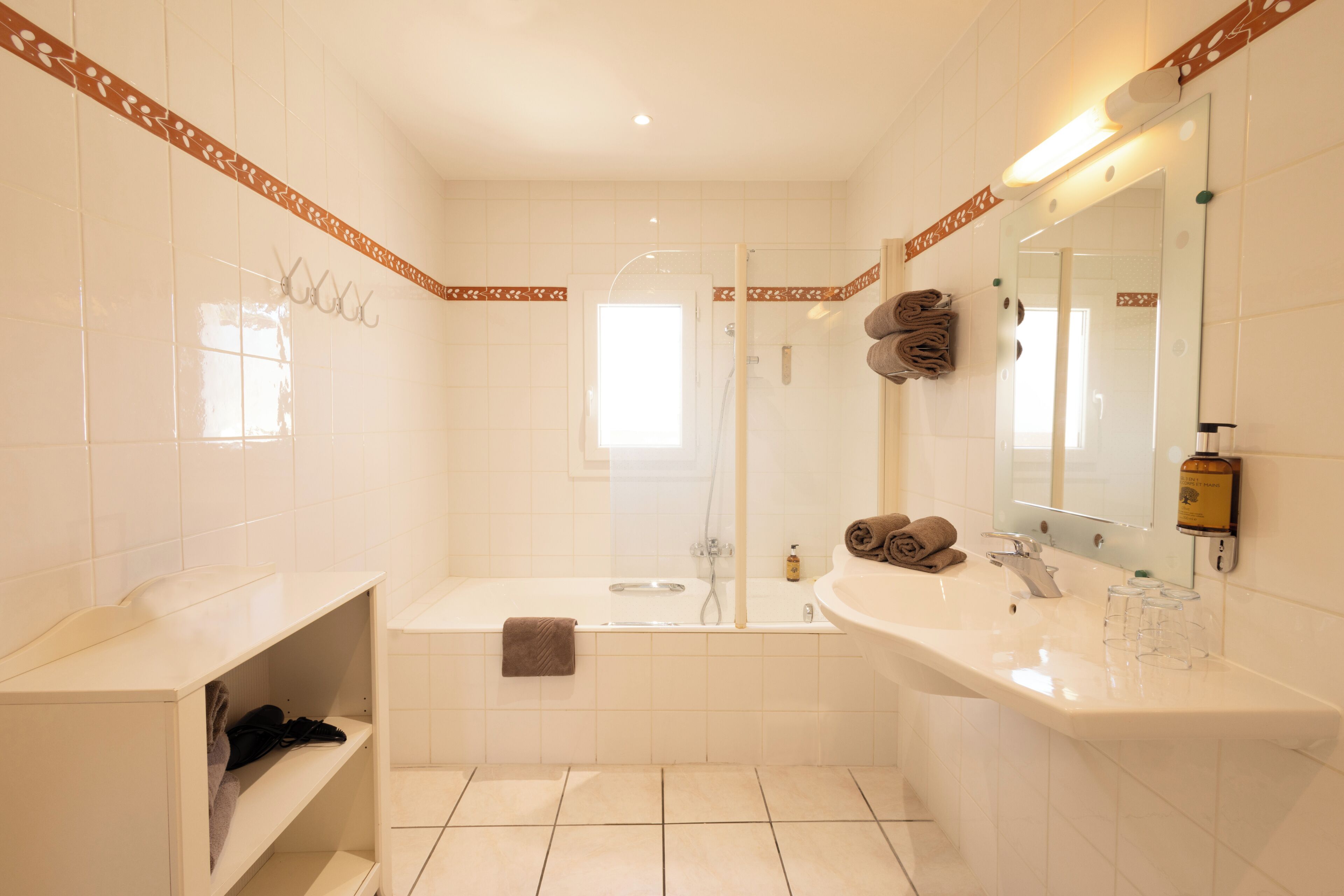 Een badkamer met een bad, wastafel, spiegel en douche.