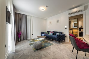 A modern living room with a sofa, ottoman, and a coffee table.