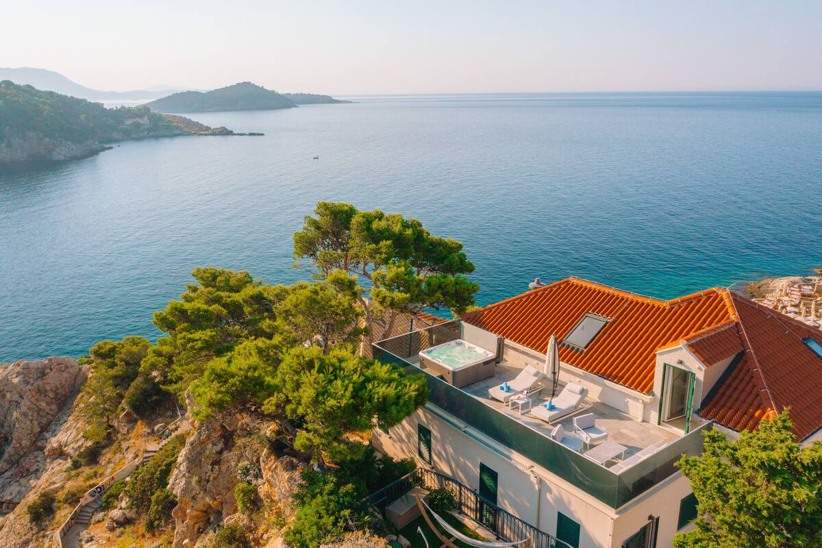 A coastal villa with a rooftop pool, terraced garden, and ocean views.