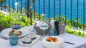 A table set for a meal with a view of the sea.