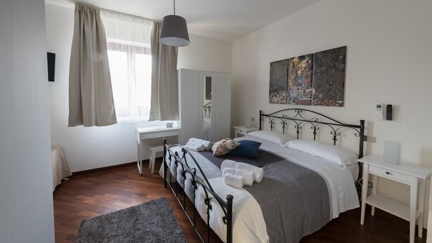 A bedroom with a bed, bedside tables, a desk, a wardrobe, and a painting on the wall. - Ellebì B&B (Mosciano Sant'Angelo)