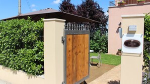 A gated entrance with a wooden door, a small outdoor seating area, and a mailbox with a nameplate. - Ellebì B&B (Mosciano Sant'Angelo)