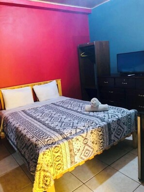 Ein Hotelzimmer mit einem Bett, einem Fernseher und einem Kleiderschrank.