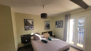 Habitación de hotel con una cama grande, dos mesitas de noche y ventana con vista al exterior.