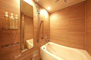 Ein Badezimmer mit Badewanne, Spiegel und Holzverkleidung.