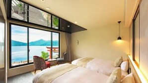 A hotel room with two beds, a large window with a mountain view, a small table, and a chair. - Nikko Chuzenji-ko Onsen Hotel Hana-An (Nikko)