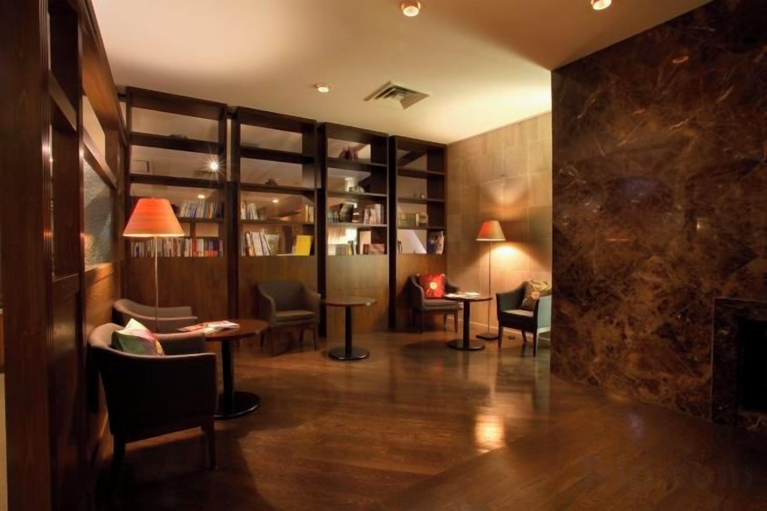 A library with bookshelves, reading chairs, and tables.