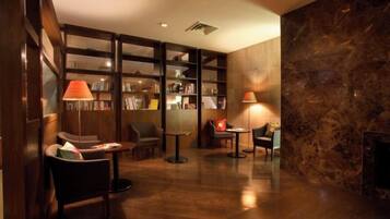 A library with bookshelves, reading chairs, and tables.