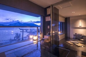 A modern hotel room with a large window overlooking a body of water and mountains, a glass partition, and a minimalist interior design. - Nikko Chuzenji-ko Onsen Hotel Hana-An (Nikko)