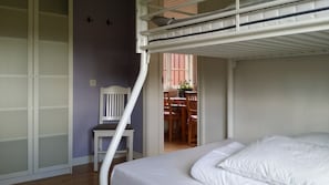A bunk bed room with a chair and a table in the background. - Knut's Camping och Lägenheter (Torsby)