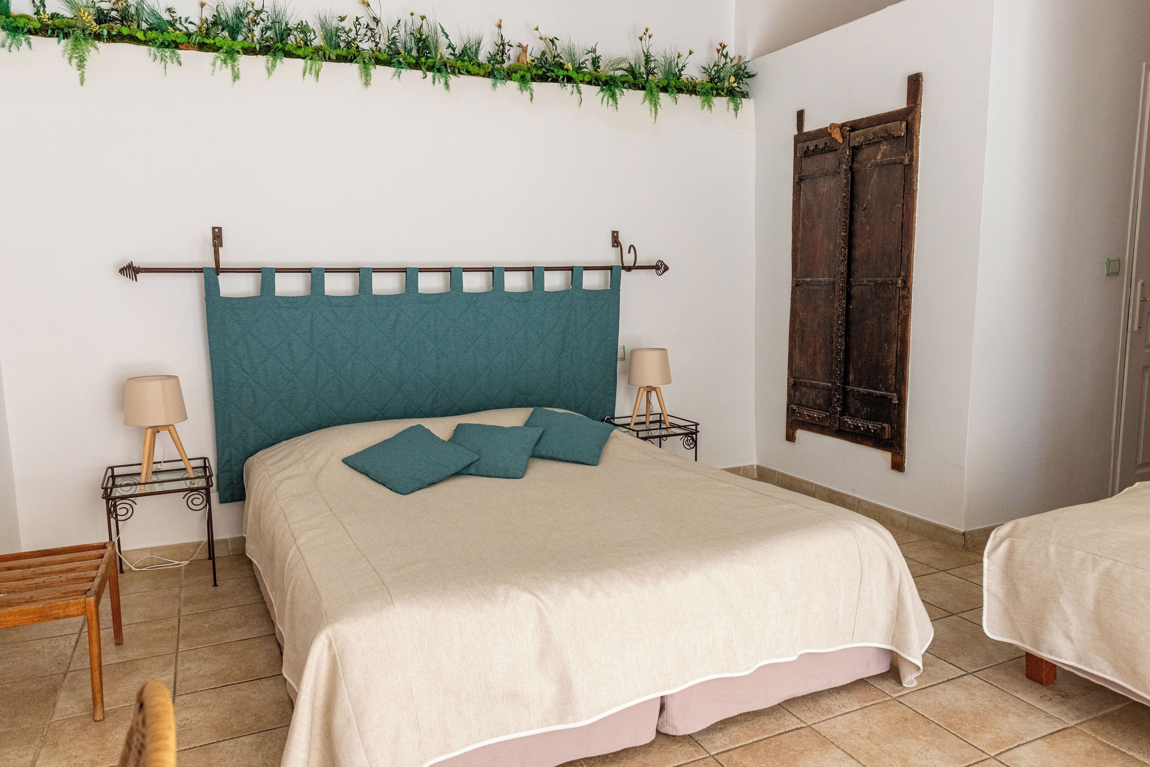 Une chambre à coucher avec un lit, des tables de chevet, une lampe et une porte en bois.