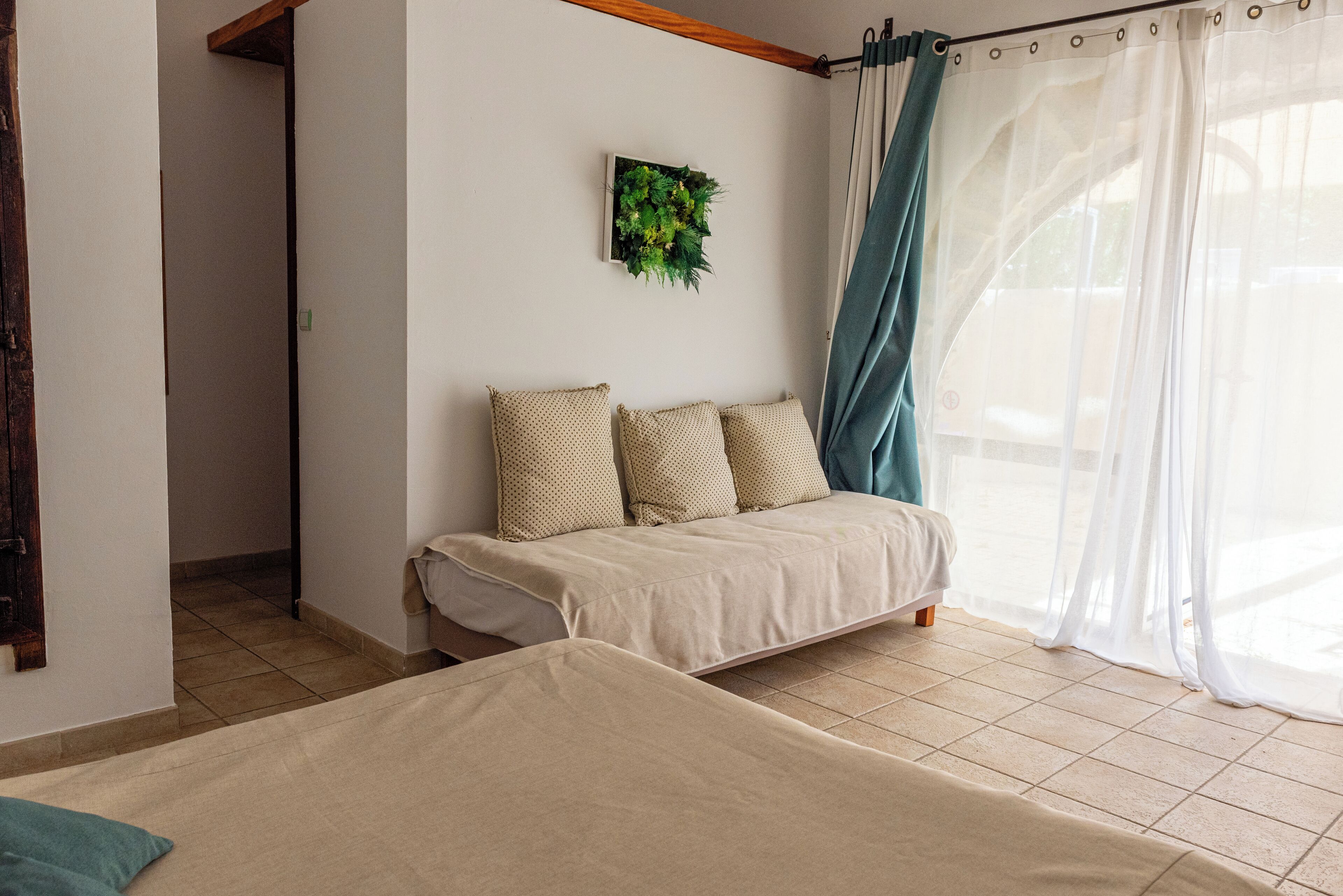 Une chambre à coucher avec un lit, un canapé et une fenêtre avec des rideaux.