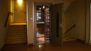Un pasillo con una escalera que da a un ascensor.