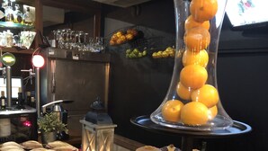 Ein Buffet mit verschiedenen Gebäcken und einer Glasvase mit Orangen.