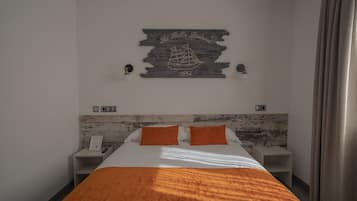 Une chambre d’hôtel comprenant un lit, deux tables de chevet, une tête de lit en bois, une œuvre d’art accrochée au mur et un rideau.