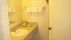 A bathroom with a sink, mirror, and towel rack. - Pawnee Inn (Wichita)