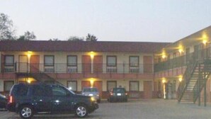 A motel with multiple rooms, a parking lot, and a fire escape. - Pawnee Inn (Wichita)