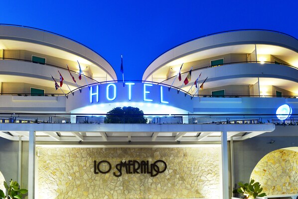 A hotel with a prominent 'HOTEL' sign and 'LO MERMADO' branding.